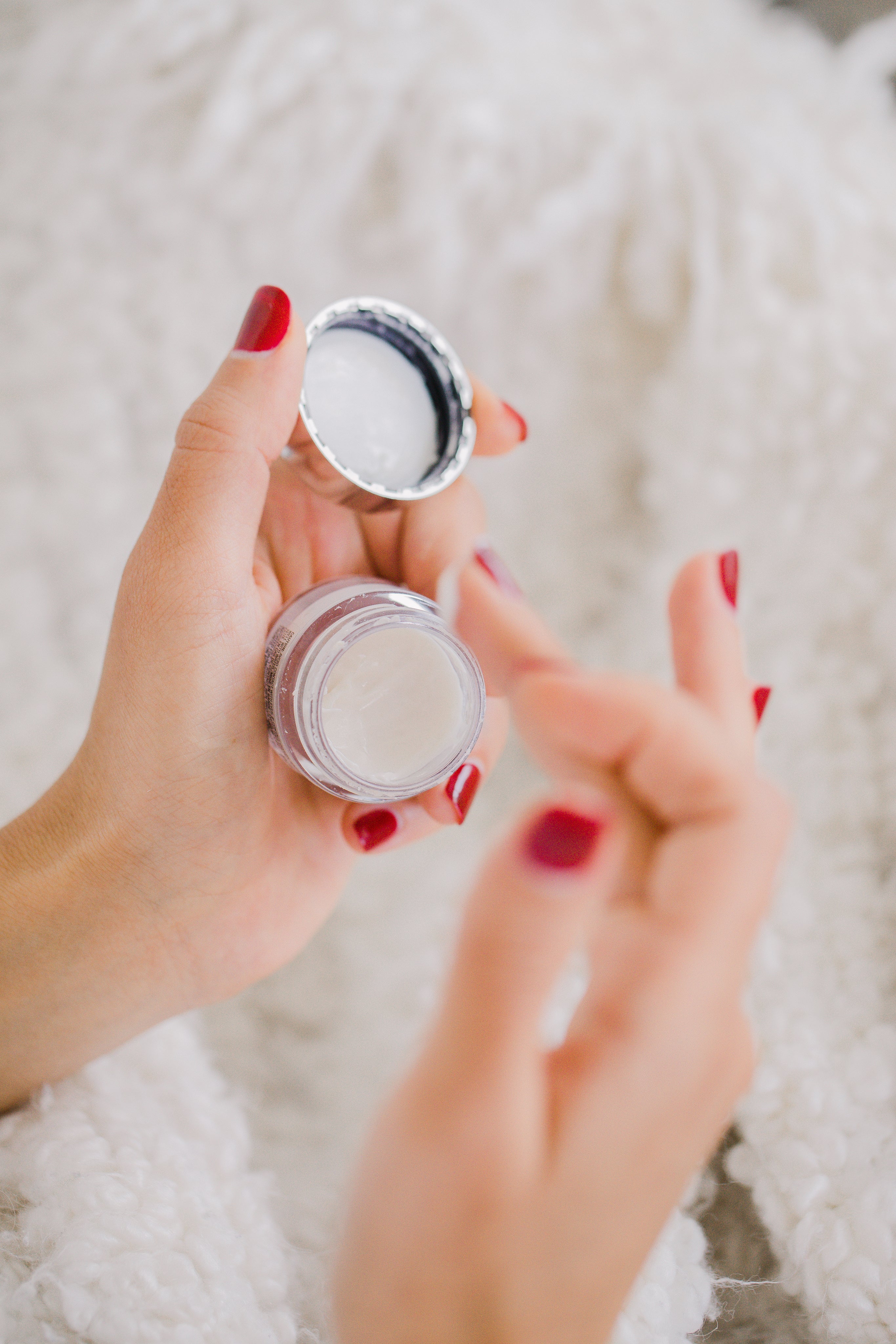 Klein potje bodybutter wat met de vingers eruit wordt gehaald